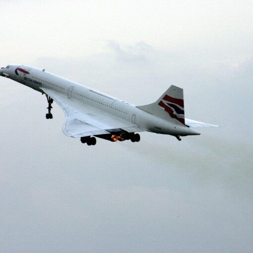 British Airways Concorde taking off with landing gear extended and afterburners active.