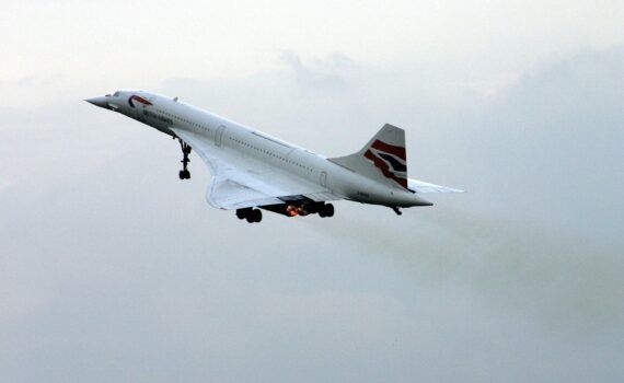 British Airways Concorde taking off with landing gear extended and afterburners active.